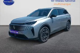 Peugeot 5008 gris artense en 3/4 avant droit, avec calandre distinctive et jantes alu modernes.