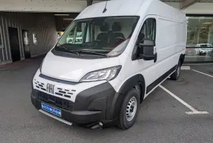 Fiat Ducato Fourgon blanc en vue 3/4 avant droit, avec pare-chocs noir et calandre distinctive, stationné en extérieur.
