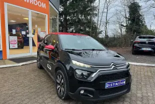 Citroën C3 Shine 2023 noir avec toit rouge, vue 3/4 avant droit devant un showroom orange.