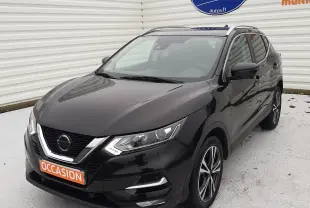 Vue 3/4 avant droit d'un Nissan Qashqai noir 2020 avec jantes alliage et calandre chromée, stationné devant un mur blanc.