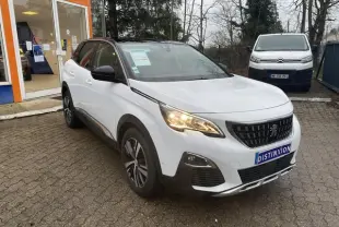 Peugeot 3008 blanc vue 3/4 avant droit avec toit noir et jantes alliage bi-ton sur parking extérieur.
