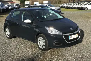 Peugeot 208 bleu foncé vue 3/4 avant droit avec rétroviseurs blancs sur un parking extérieur.