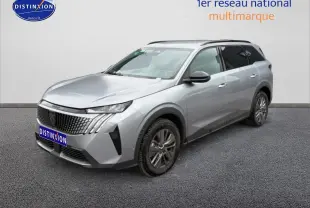 Peugeot 5008 gris artense en 3/4 avant droit, avec calandre distinctive et jantes alu visibles.