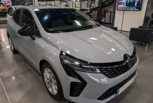 Renault Clio V Blue dCi 100 en gris Rafale, vue 3/4 avant droit dans un showroom lumineux.