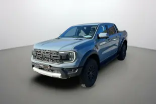 Ford Ranger Raptor gris commandeur vu en 3/4 avant droit avec calandre imposante et pneus tout-terrain.