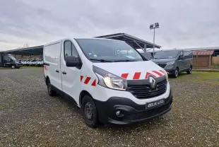 Renault Trafic Fourgon blanc en 3/4 avant droit avec bandes rouges réfléchissantes sur capot et portières.