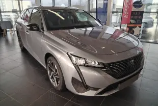 Peugeot 308 SW Hybrid gris Artense vue 3/4 avant gauche en showroom avec jantes bi-ton et calandre noire.