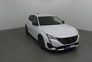 Peugeot 308 blanc Okenite vue 3/4 avant droit, avec calandre noire et feux LED distinctifs.