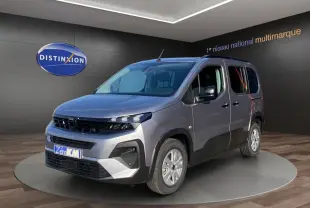 Peugeot Rifter gris acier en 3/4 avant droit, avec jantes alliage et barres de toit noires visibles en showroom.