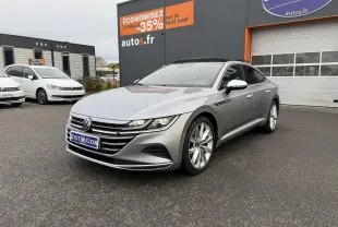 Volkswagen Arteon gris pyrite métallisé vue 3/4 avant droit avec jantes alliage 19 pouces devant un garage autos.fr