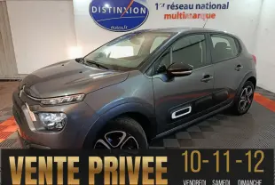 Citroën C3 BlueHDi 100 gris foncé vue 3/4 avant droit, avec protections latérales noires et jantes stylisées.