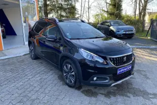 Peugeot 2008 noir métallisé vue 3/4 avant droit avec jantes aluminium 16 pouces et calandre distinctive.