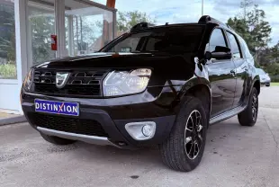 Dacia Duster noir métal vu en 3/4 avant droit, mettant en valeur sa calandre distinctive et ses jantes bi-ton.