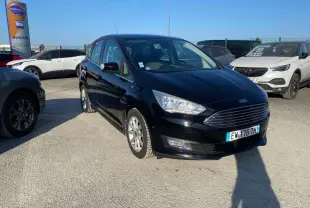 Vue 3/4 avant d'une Ford C-MAX noire 2017 avec calandre chromée et jantes alliage 16 pouces sur parking.