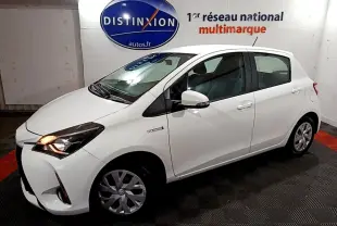 Toyota Yaris hybride blanche vue de profil droit 3/4 avant, avec phares allumés et jantes alliage.
