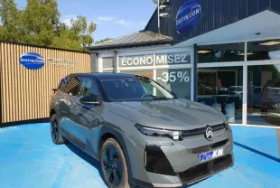 Vue 3/4 avant droite du Citroën C5 Aircross vert Astoria avec jantes noires devant un showroom Distinxion.