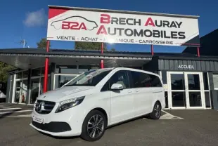 Mercedes Classe V 250 d blanc cristal de roche métallisé, vue 3/4 avant droit devant un garage Brech Auray Automobiles