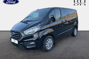 Ford Transit Custom Fourgon noir Agate métallisé, vue 3/4 avant droit avec calandre chromée et jantes alu 16 pouces.