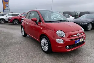 Fiat 500 rouge vue 3/4 avant droit avec jantes alliage et détails chromés sur parking extérieur.