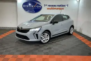 Renault Clio gris clair vue 3/4 avant droit, avec feux LED allumés et jantes alliage, en intérieur showroom.