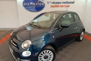 Vue 3/4 avant droite d'une Fiat 500 Dolcevita bleue avec jantes alliage et logo distinctif sur l'aile avant.