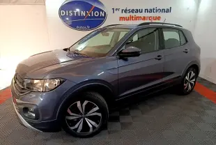 Volkswagen T-Cross gris foncé en 3/4 avant droit, avec jantes distinctives et toit noir en showroom.