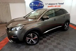 Peugeot 3008 gris clair en 3/4 avant droit, avec jantes alliage et toit panoramique en intérieur showroom.