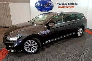 Volkswagen Passat SW hybride rechargeable gris foncé vue 3/4 avant droit, jantes alliage et feux LED allumés.