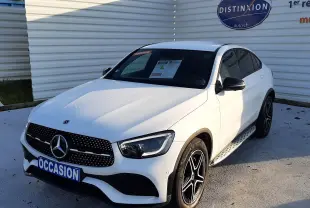 Mercedes GLC Coupé 300 4MATIC AMG blanc vu en 3/4 avant droit, avec jantes noires et calandre à étoiles chromées.