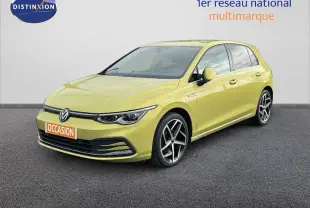 Volkswagen Golf 1.5 eTSI jaune vue 3/4 avant droit sur sol gris devant un mur blanc.