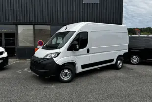 Peugeot Boxer Fourgon blanc en vue 3/4 avant droit, avec pare-chocs noirs et jantes acier simples.