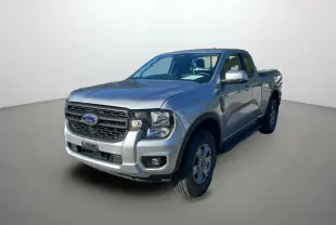 Ford Ranger 2025 gris iconic en 3/4 avant droit, avec calandre noire et cabine Supercab visible côté droit.