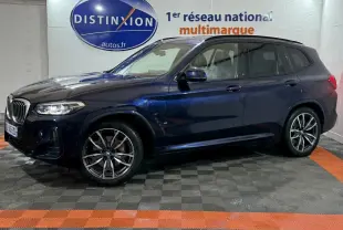 BMW X3 xDrive30e bleu en vue de profil côté gauche dans un showroom avec logo Distinxion en arrière-plan.