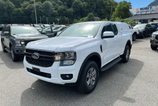 Ford Ranger blanc glacier 2025 en 3/4 avant droit avec hard-top sur la benne et jantes alliage.