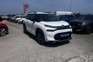 Citroën C3 Aircross blanc banquise en 3/4 avant droit avec barres de toit noir brillant sur parking.