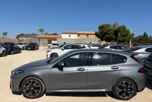 BMW Série 1 118d M Sport gris métallisé vue profil côté gauche sur parking ensoleillé