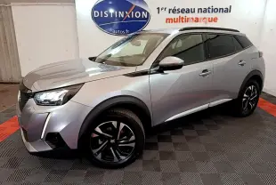 Peugeot 2008 gris clair en 3/4 avant droit, avec jantes noires et toit noir, dans un showroom intérieur.