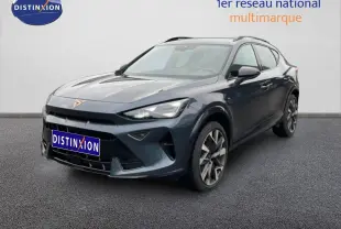 Vue 3/4 avant d'une CUPRA Formentor gris magnétique métal avec logo cuivré, dans un showroom intérieur.