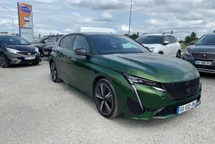 Peugeot 308 Vert Olivine vue 3/4 avant droit, avec calandre noire et feux LED en forme de griffes.