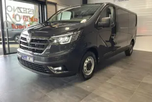 Renault Trafic Fourgon gris Comète en 3/4 avant droit, avec projecteurs Full LED allumés en showroom.