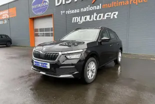Vue 3/4 avant d'un Skoda Kamiq noir magic nacré avec calandre chromée et jantes argentées sur parking humide.