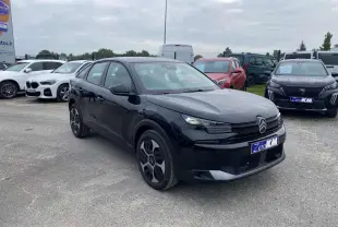 Citroën C4 hybride noire Perla Nera vue 3/4 avant droit, avec jantes spécifiques et calandre moderne.