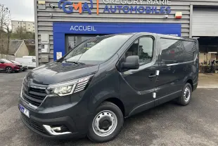 Fourgon Renault Trafic Advance gris Comète vu en 3/4 avant droit devant un garage Gregory Marie Automobiles.