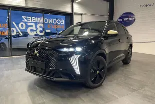 DS7 Crossback noir métallisé en 3/4 avant droit, avec calandre DS Wings et rétroviseurs couleur crème visibles en intérieur showroom.