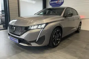 Peugeot 308 gris Artense vue 3/4 avant droit en showroom avec calandre noire et feux LED distinctifs.