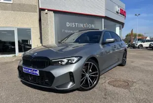 BMW Série 3 320dA Skyscrapergrau métallisé vue 3/4 avant droit avec jantes M bicolores et calandre noire brillante.