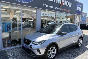 SEAT Arona 2024 gris GRS en 3/4 avant droit, avec jantes alliage 16 pouces et calandre noire distinctive.