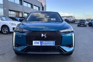 Vue avant d'une DS3 1.2 Hybride bleu avec calandre noire à motif losange et feux LED verticaux allumés.