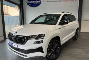 Vue 3/4 avant droite d’un SUV Skoda Karoq blanc 2025 avec calandre noire et jantes alliage noires Sportline.