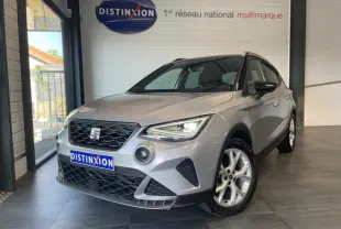 SEAT Arona 2024 gris GRS en 3/4 avant droit, avec calandre noire et jantes alliage 16 pouces visibles.